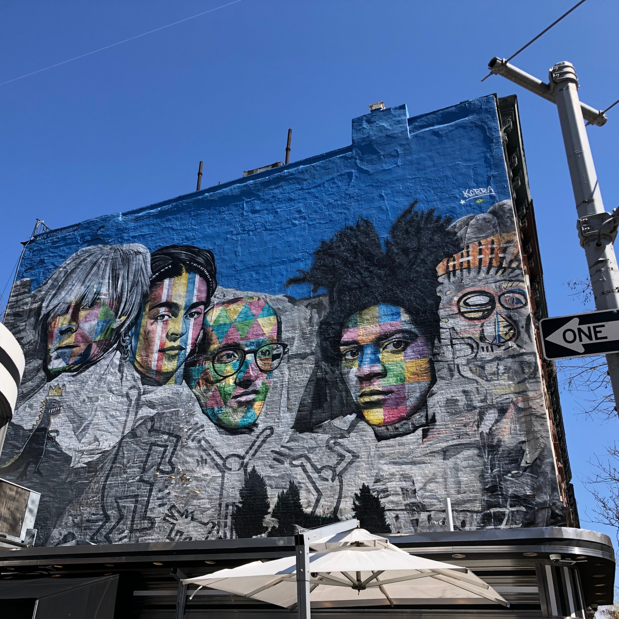 Colorful wall mural of Andy Warhol, Frida Kahlo, Keith Haring, and Jean-Michel Basquiat on Mount Rushmore