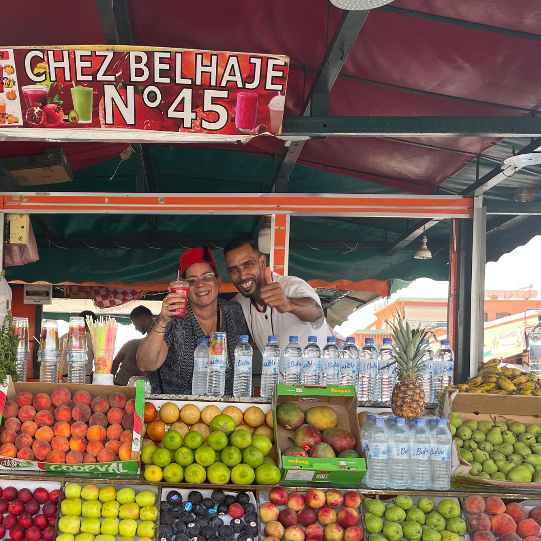 A man and woman (the author) above a display of fruits at the Marrakesh medina.