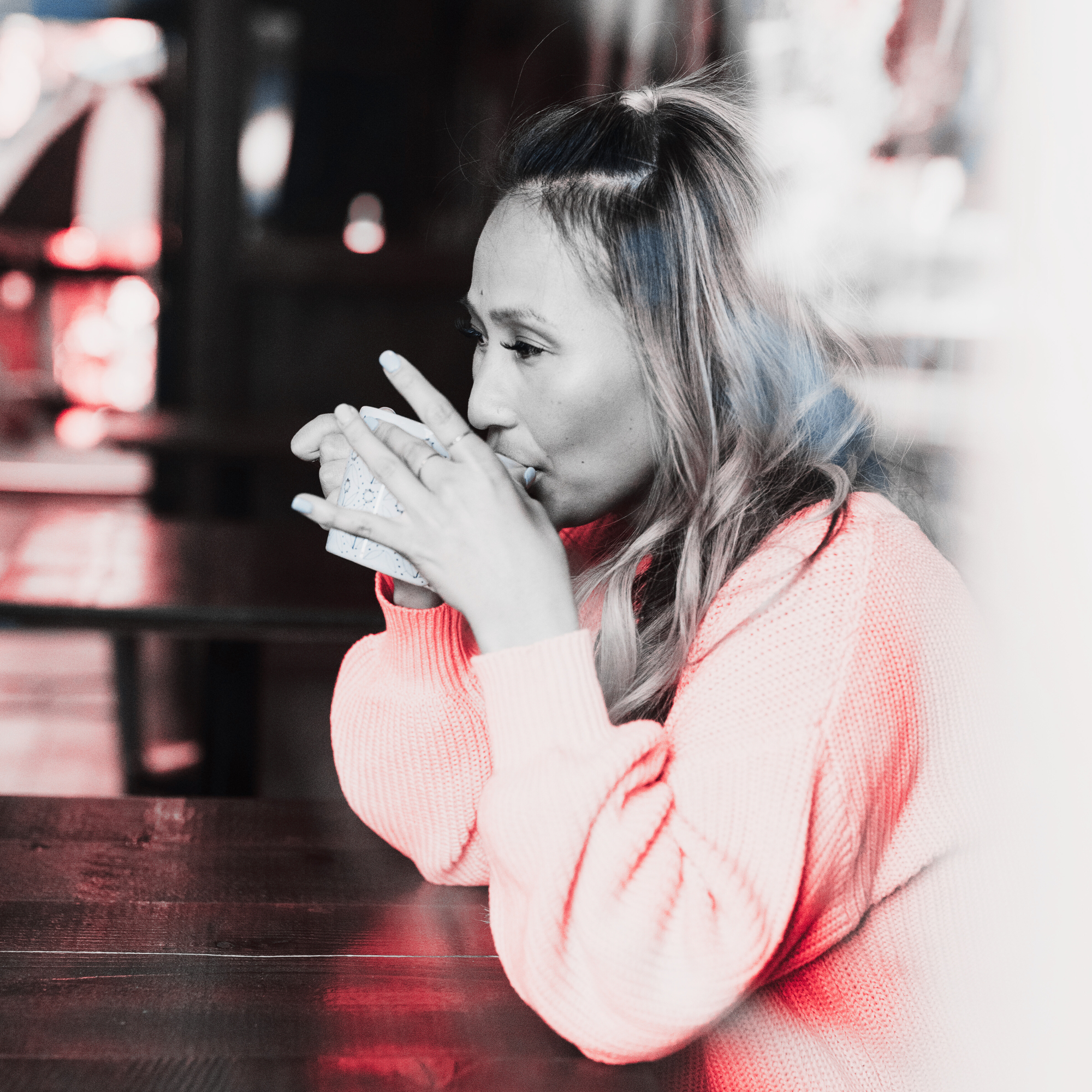 Photo of a woman sipping coffee from a mug.
