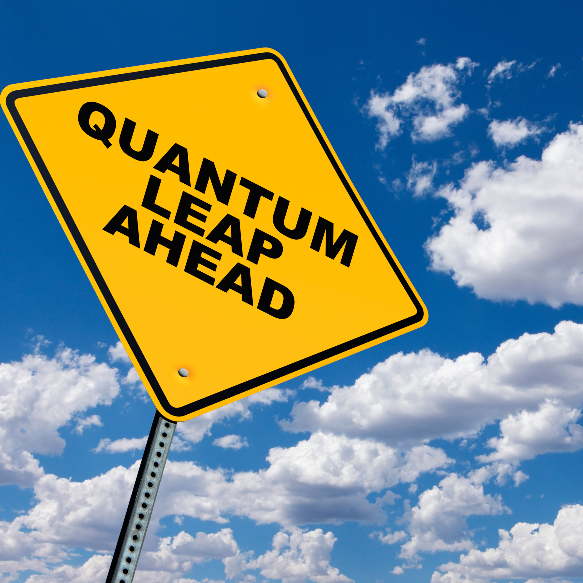 Photo of a yellow yield sign that reads "quantum leap of ahead" with a background of white clouds on a blue sky.