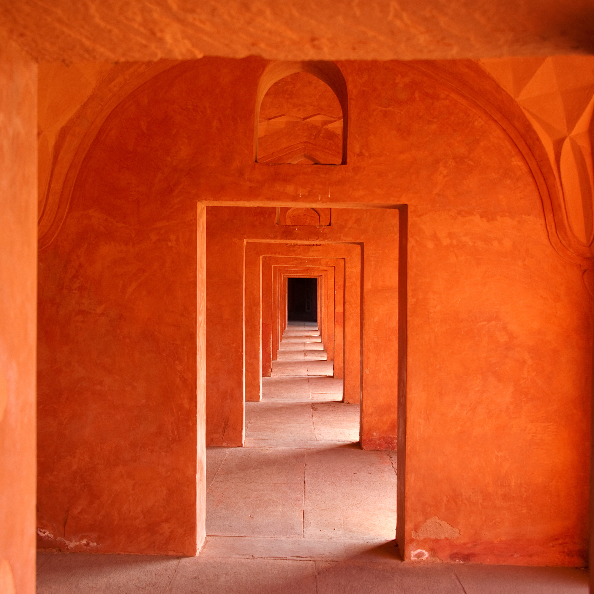 Photo of a series of bright orange painted walls with successive doorways