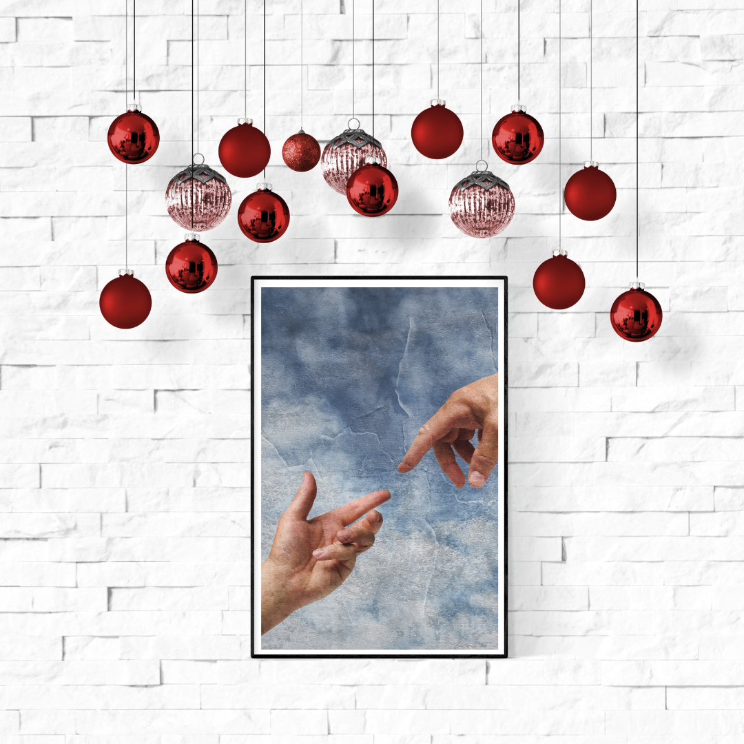 white brick way with red holiday ornaments hanging above it; a framed image of two hands reaching out, fingers about to touch